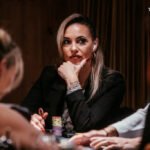 Ein bunt gemischter Stapel von Pokerchips in verschiedenen Farben und Werten liegt auf einem grünen Pokertisch.