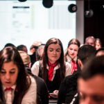Ein professioneller Pokertisch mit grünem Filz, umgeben von Spielkarten, Pokerchips und Getränken, in einem stilvollen Raum mit gedämpftem Licht und eleganten Möbeln.