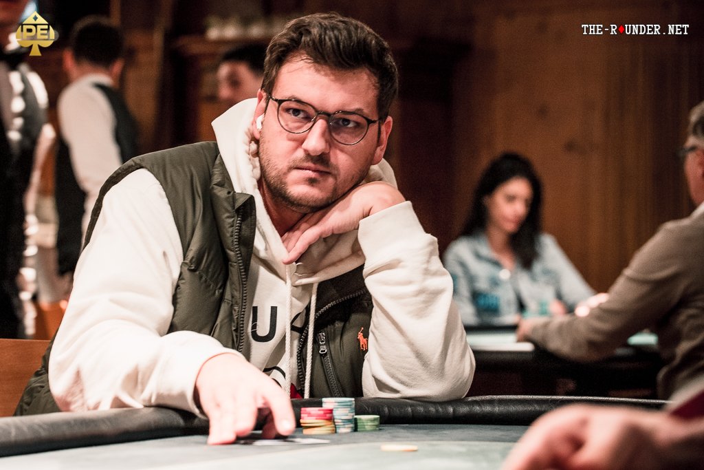 Ein Haufen Pokerchips in verschiedenen Farben und Werten, der auf einem grünen Pokertisch liegt.
