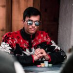 Ein Mann und eine Frau sitzen an einem Pokertisch und halten Karten in der Hand. Sie schauen konzentriert auf ihre Karten und scheinen in einem ernsten Pokerspiel vertieft zu sein.
