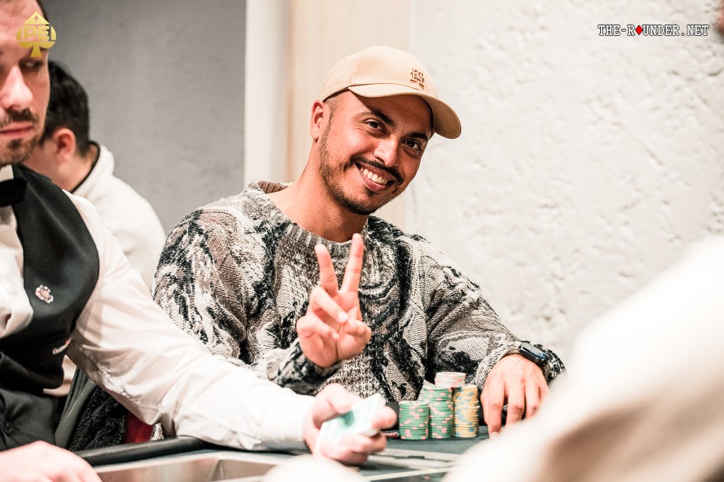 Ein Mann und eine Frau sitzen zusammen an einem Pokertisch und spielen Karten. Der Mann hält seine Karten in der Hand, während die Frau konzentriert auf ihre Karten schaut. Die Atmosphäre ist gespan