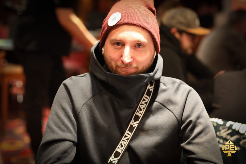 Ein professioneller Pokertisch mit grünem Filz, umgeben von Stühlen und Chips. In der Mitte des Tisches liegen Spielkarten und Spieler warten gespannt auf ihre nächsten Züge.
