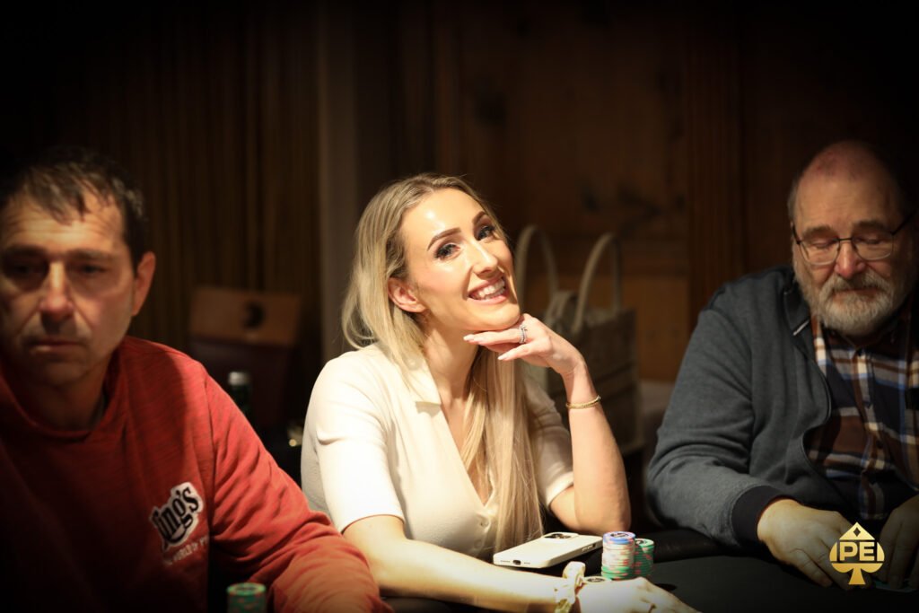 Ein Mann und eine Frau sitzen an einem Pokertisch und betrachten konzentriert ihre Karten. Die Szene ist in einem eleganten Pokerraum mit grünen Filzdecken und Pokerchips im Vordergrund