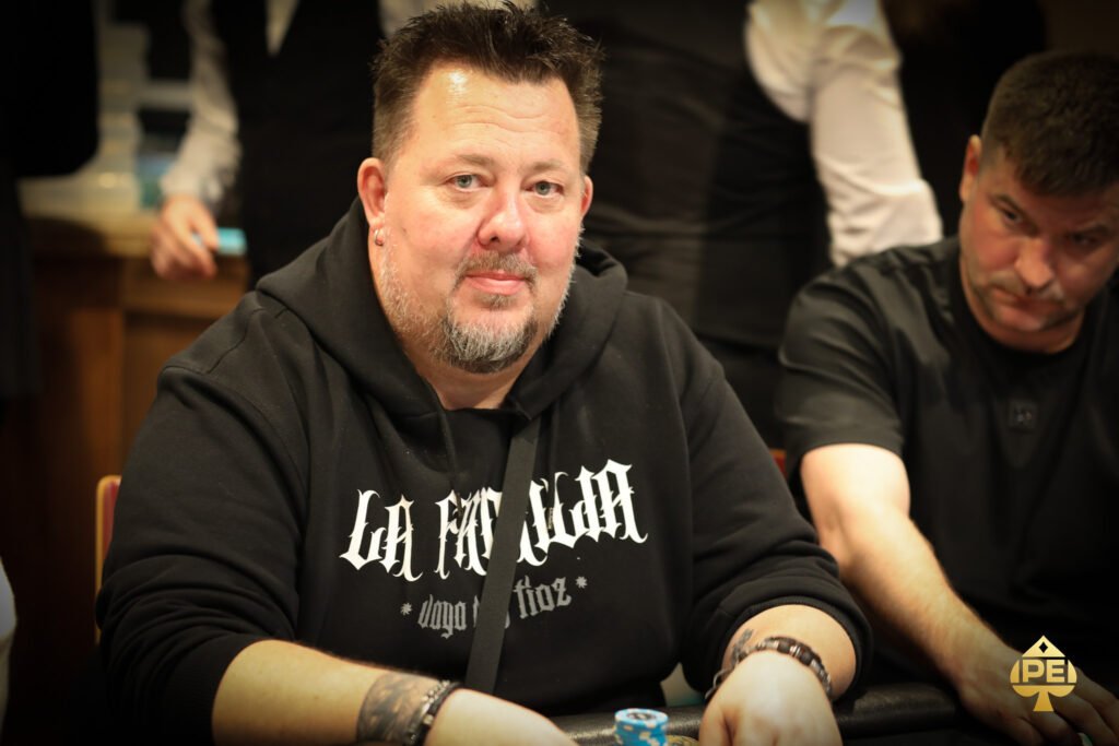 Ein Mann und eine Frau spielen Poker an einem eleganten Spieltisch in einem luxuriösen Casino. Der Mann hält Karten in der Hand, während die Frau konzentriert auf ihre eigenen Karten schaut. Im Hinter