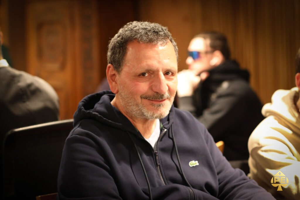 Ein Bild eines Pokertisches mit Pokerchips, Karten und Getränken während eines spannenden Spiels.