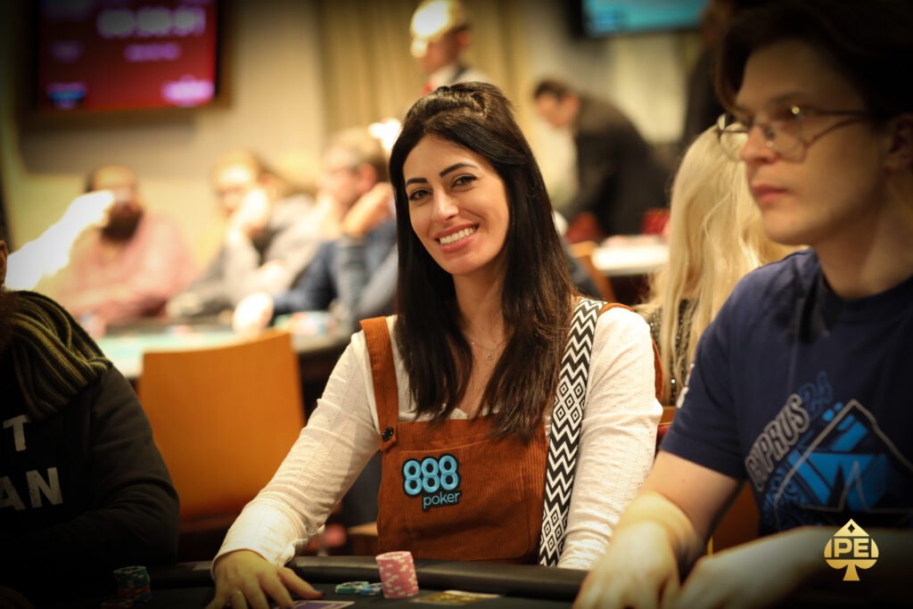 Ein professioneller Pokertisch mit grünem Filz, umgeben von Stühlen, Chips und Karten. Zwei Spieler in Anzügen sitzen einander gegenüber und betrachten konzentriert ihre Karten. Die