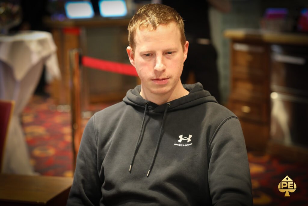 Ein Mann und eine Frau spielen eine intensive Partie Poker in einem eleganten Casino. Der Mann hält seine Karten geheim, während die Frau mit konzentriertem Blick ihre Chips setzt. Die Atmosphäre ist gespannt
