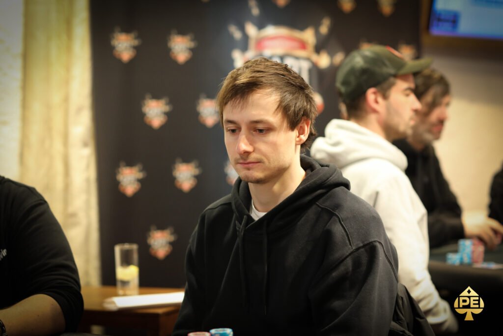 Ein Mann und eine Frau spielen Poker an einem eleganten Tisch in einem luxuriösen Casino. Der Mann hat Karten in der Hand und setzt Chips, während die Frau konzentriert ihre Karten betrachtet. Die Sz