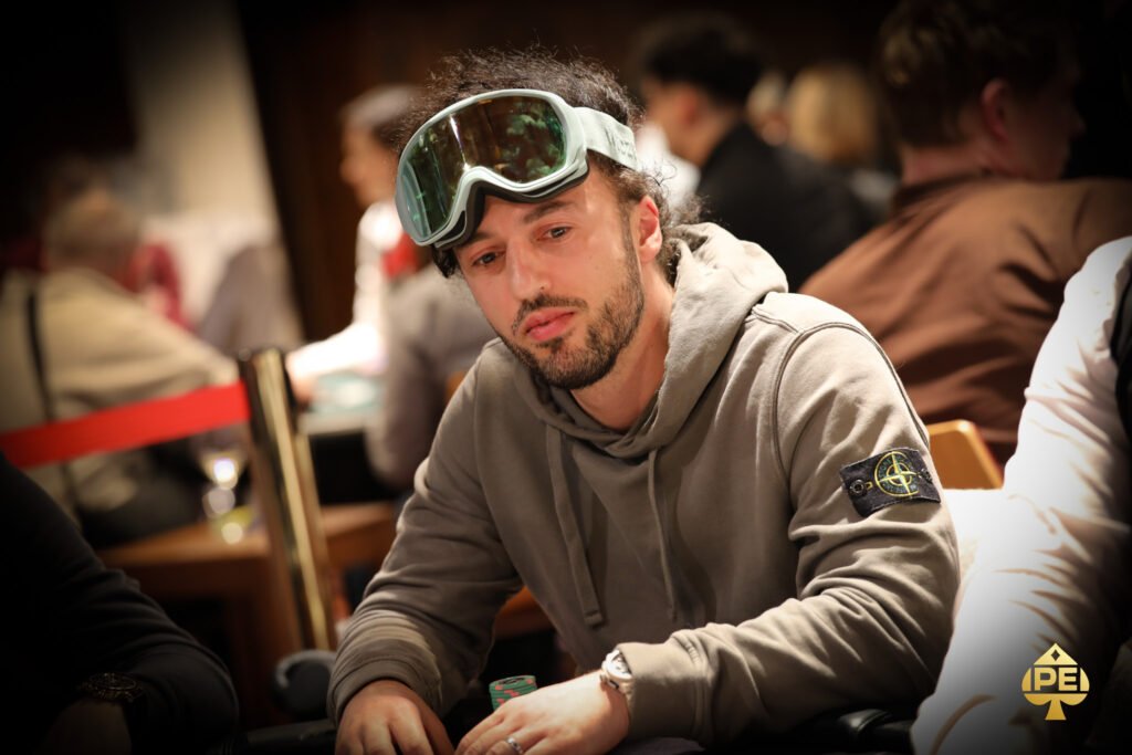 Ein Mann und eine Frau sitzen an einem Pokertisch und spielen eine Partie Texas Hold'em. Der Mann hat gerade seine Karten angesehen und überlegt, während die Frau mit gespanntem Blick auf ihre eigenen Karten wartet