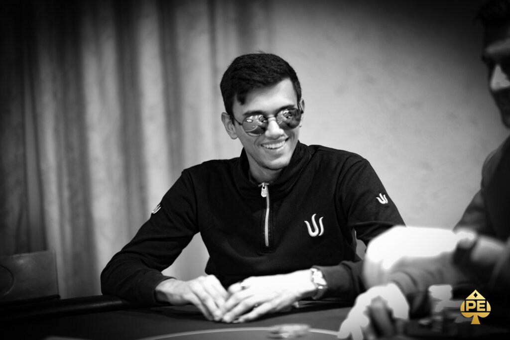 Ein Mann und eine Frau sitzen an einem Pokertisch und spielen Texas Hold'em. Der Mann hat eine Hand aus Spielkarten, während die Frau nachdenklich ihre Karten betrachtet. Das Bild strahlt eine Atmosph