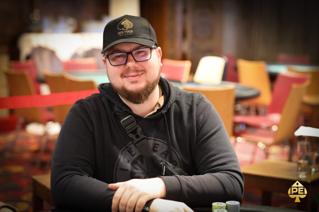 Ein professioneller Pokerspieler konzentriert sich intensiv auf seine Karten während eines Turniers.