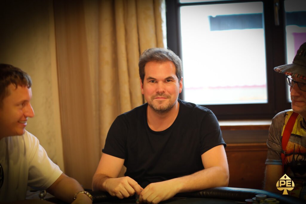 Ein Mann und eine Frau sitzen an einem Pokertisch und spielen Texas Hold'em. Der Mann hat gerade gewonnen und jubelt, während die Frau enttäuscht wirkt. Die Szene spielt in einem eleganten Casino mit
