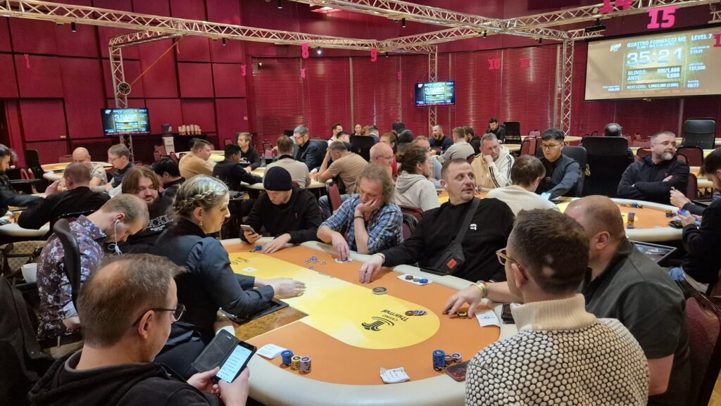 Ein Stapel grüner Pokerchips auf einem Tisch mit Spielkarten und einem Dealer-Button.