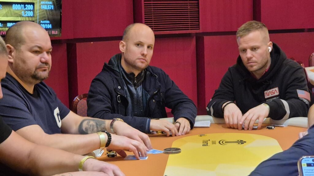 Ein Spieler hält zwei Könige (König-König) in seinen Händen während einer Pokerrunde.
