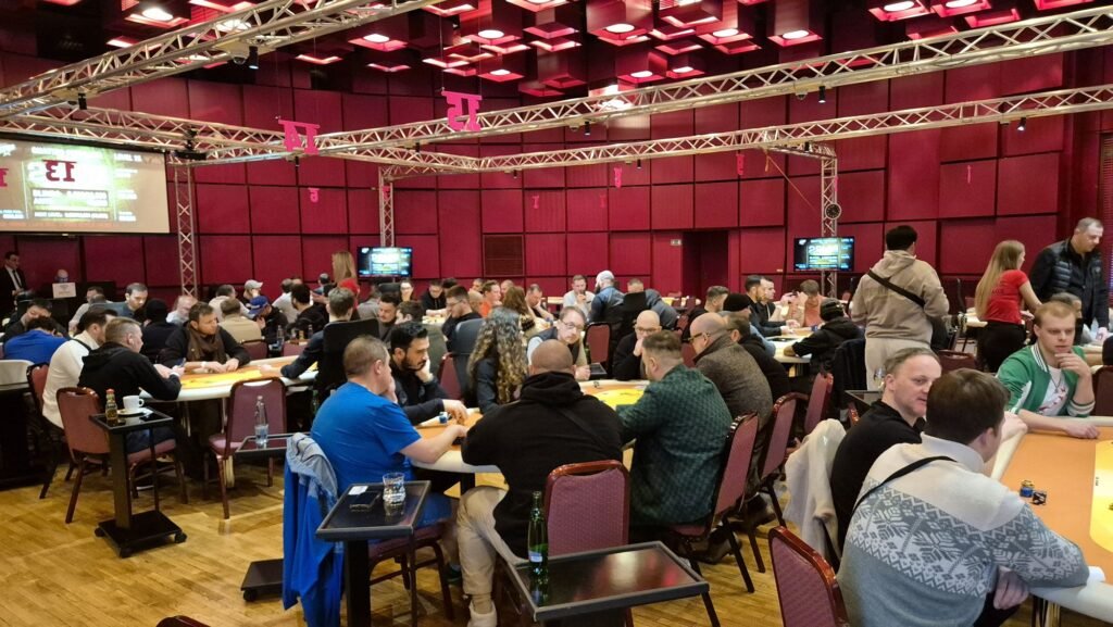 Ein Stapel Pokerchips in verschiedenen Farben auf einem grünen Pokertisch.
