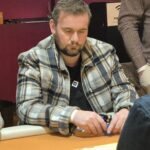 Ein professioneller Pokertisch mit grünem Filz, umgeben von Spielkarten, Jetons und einem Dealer-Button.