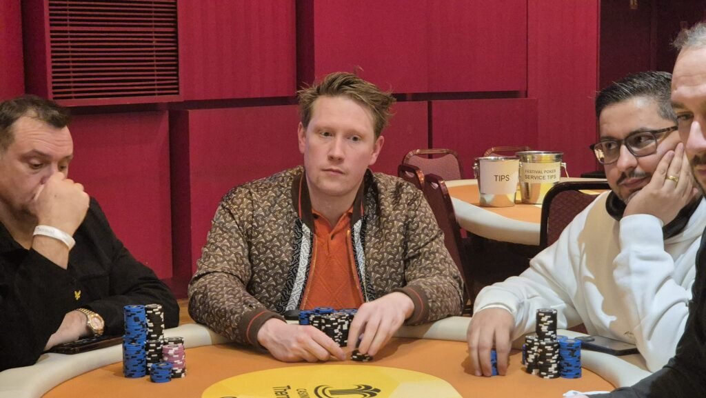 Ein professioneller Pokertisch mit grünem Filz, umgeben von Stühlen und Chips, bereit für ein spannendes Pokerspiel.