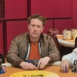 Ein professioneller Pokertisch mit grünem Filz, umgeben von Stühlen und Chips, bereit für ein spannendes Pokerspiel.