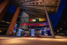 An elegant entrance to the Berlin Casino with modern design and glass facade. A large double-door glass entrance with golden door handles and discreet security.