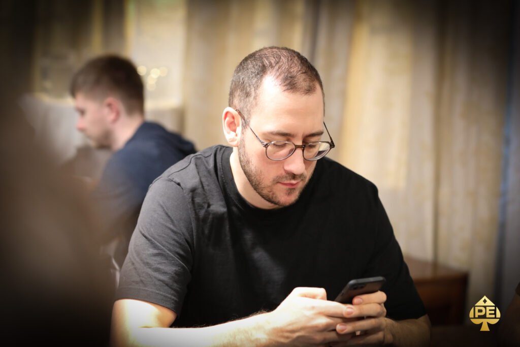 Ein Mann und eine Frau sitzen an einem Pokertisch und spielen Karten. Der Mann hat einen Anzug an, die Frau trägt ein elegantes Abendkleid. Die Atmosphäre ist konzentriert und spannend