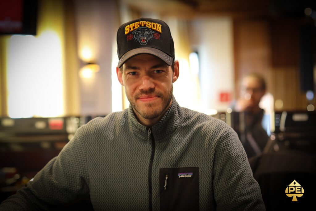 Ein professioneller Pokerspieler konzentriert sich auf sein Kartenspiel während eines Turniers.