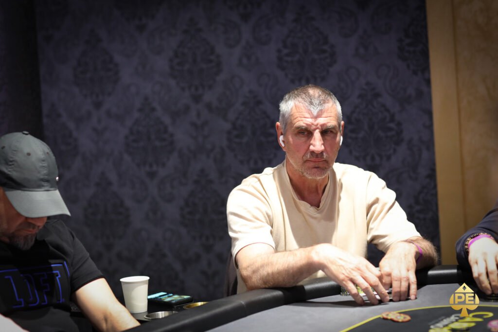 Ein Mann und eine Frau spielen Poker an einem eleganten Tisch in einem luxuriösen Casino, umgeben von Chips und Karten.